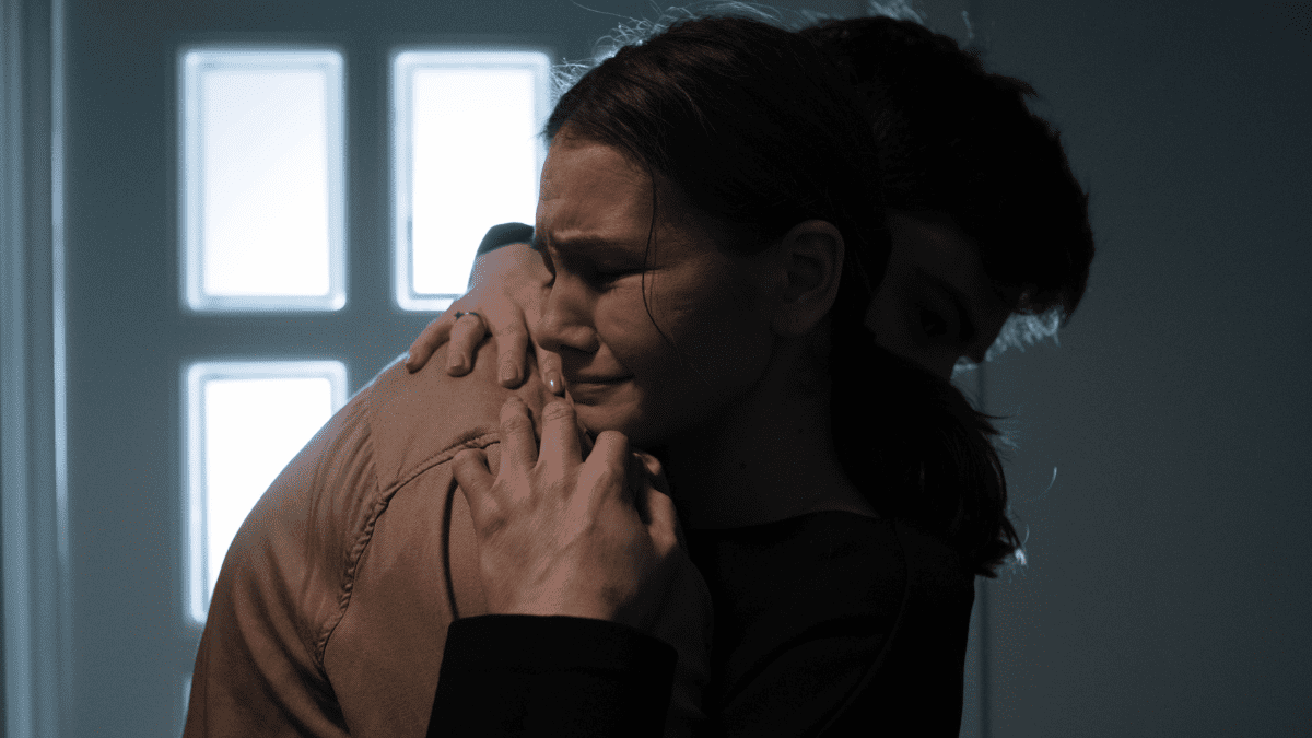 a woman grieving and hugging someone